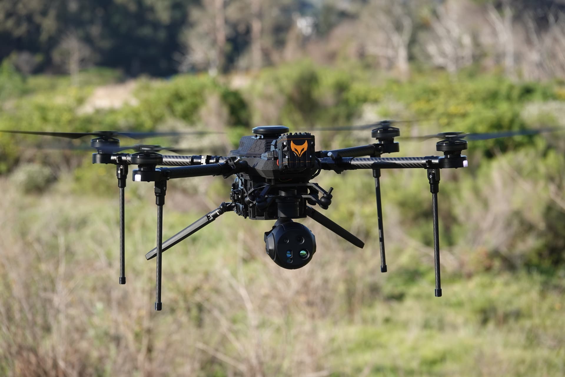 TCAT RECCE surveillance drone hovering over open terrain during a reconnaissance mission