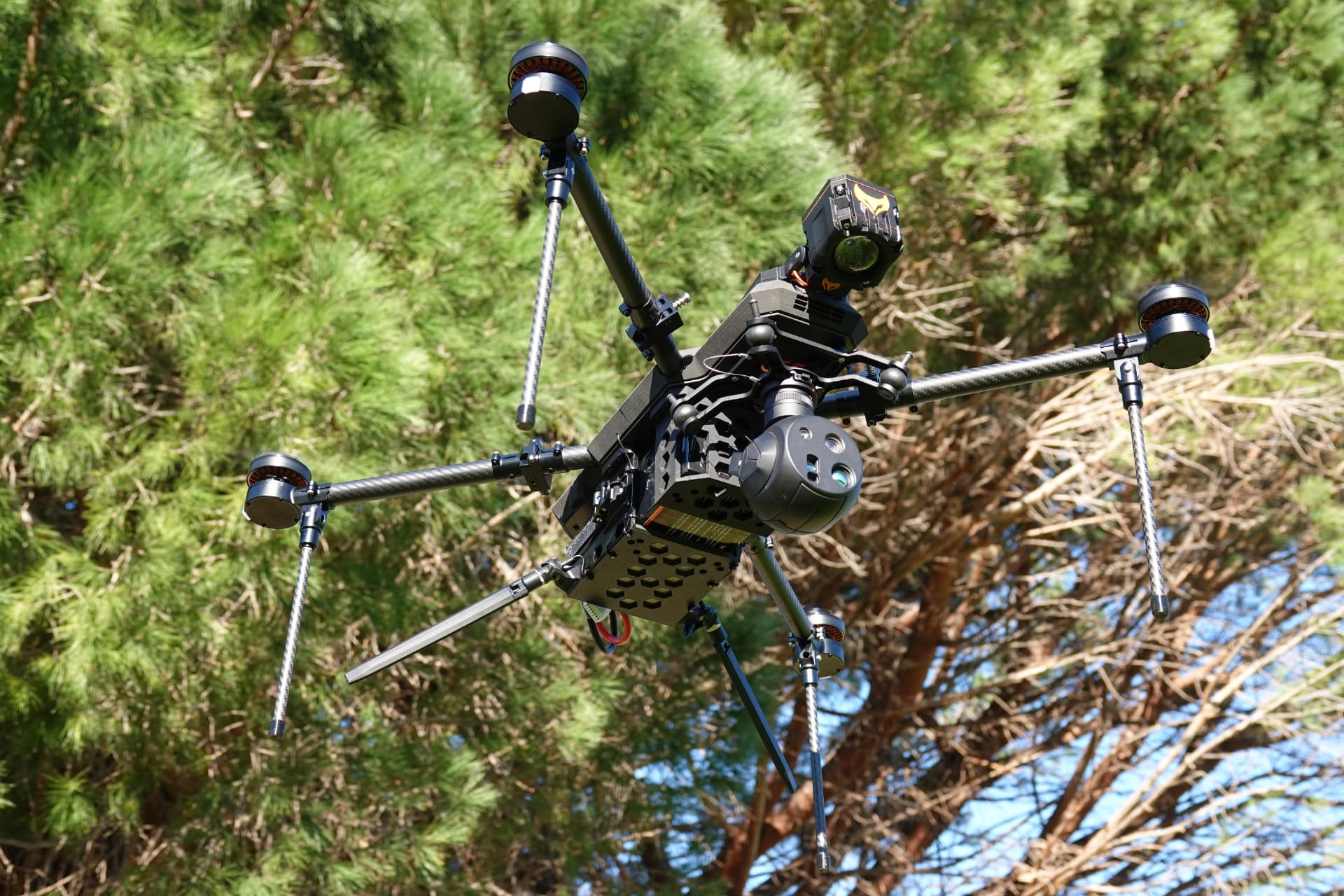 TCAT RECCE reconnaissance drone banking above a treeline